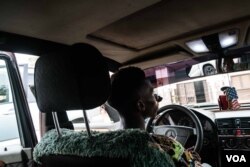 Taxi driver Eduardo poses for a portrait in his taxi. He asked to have his identity hidden, but said the government impasse has dealt a blow to his income, Dec. 14, 2017. (R. Shyrock)