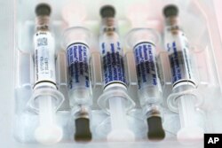 A file photo showing flu vaccine syringes in 2020. Experts are expecting a bad flu season in the U.S. this winter. (AP Photo/Damian Dovarganes)