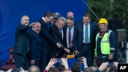Turkey's President Recep Tayyip Erdogan, center, pushes a button to commence construction of a highway as he stands along with others on a stage during a ceremony in Sremska Raca, some 80 Km. west of Belgrade, Serbia, Tuesday, Oct. 8, 2019. Erdogan…