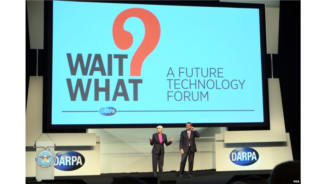 DARPA director Arati Prabhakar, left, and Defense Secretary Ash Carter welcome visitors at the opening of a conference aimed at highlighting innovative technologies and fostering an interdisciplinary approach to problem-solving. (Credit: Art Chimes/VOA)