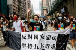 FILE- (L-R) Pan-democratic legislator Eddie Chu Hoi-dick, Vice convener for Hong Kong's Civil Human Rights Front Figo Chan, and activist Leung Kwok-hung, march at the anniversary of Hong Kong's handover to China from Britain, Hong Kong, July 1, 2020.