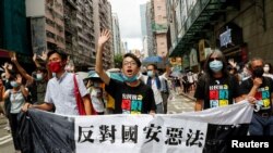 (L-R) Pan-democratic legislator Eddie Chu Hoi-dick, Vice convener for Hong Kong's Civil Human Rights Front Figo Chan, and activist Leung Kwok-hung, march at the anniversary of Hong Kong's handover to China from Britain, in Hong Kong, July 1, 2020.