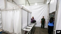 Shower stalls and sinks are seen as the U.S. Border Patrol unveiled a new 500-person tent facility, June 28, 2019, in Yuma, Arizona.
