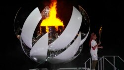 Naomi Osaka stands beside the Olympic flame after lighting it during the opening ceremony in the Olympic Stadium at the 2020 Summer Olympics, Friday, July 23, 2021, in Tokyo, Japan. (AP Photo/David J. Phillip)