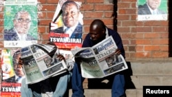 Zimbabweans read newspaper coverage of the recent elections in Mbare township, outside Harare, Zimbabwe, August 4, 2013.