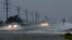 Vehicles navigate a flooded Highway 64 as wind pushes water over the road as Hurricane Arthur passes through Nags Head, N.C., July 4, 2014.
