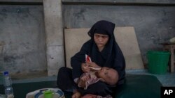 A Rohingya Muslim woman, who crossed over from Myanmar into Bangladesh, feeds her daughter inside the centre of Action contre La Faim (ACF) for malnutrition children near Kutupalong, Bangladesh, Sunday, Oct. 22, 2017.