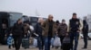 Men get off buses before reuniting with servicemen and officials of the self-proclaimed republics during the exchange of prisoners of war between Ukraine and the separatist republics near the Mayorsk crossing point in Donetsk region, Dec. 29, 2019.