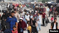 (FILE) Displaced Palestinians make their way as they flee the eastern part of Khan Younis in the southern Gaza Strip August 8, 2024.