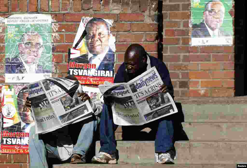 Locals read newspapers in Mbare township, outside Harare August 4, 2013. Africa&#39;s oldest president, Robert Mugabe, was declared winner of Zimbabwe&#39;s election that Saturday.