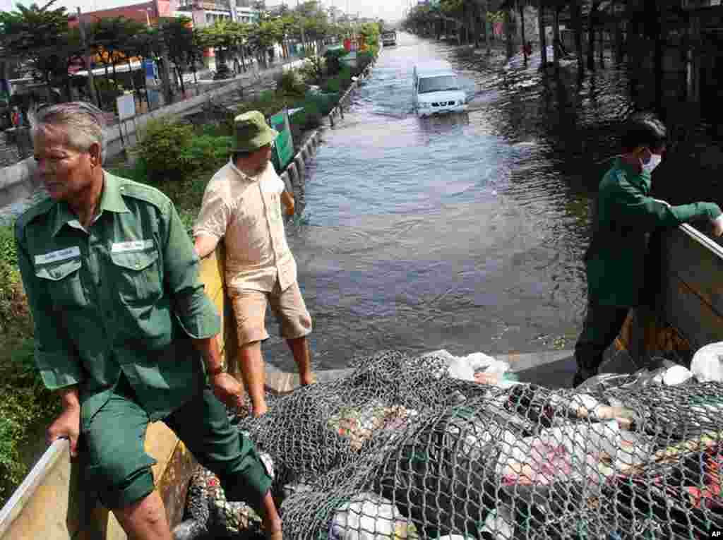 A garbage collection truck ploughs through waist-deep water in Phet Kasem, Bangkok, where waste has been piling up for six days without collection. The truck was full after just two stops, November 9, 2011. (VOA - G. Paluch)