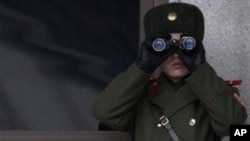 A North Korean soldier looks at the southern side through telescopes at the border village of the Panmunjom, South Korea, Wednesday, Dec. 8, 2010.