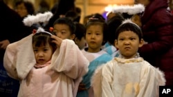 FILE - Children dressed as angels take part in a mass on the eve of Christmas at the South Cathedral official Catholic church in Beijing, China, Wednesday, Dec. 24, 2014. 