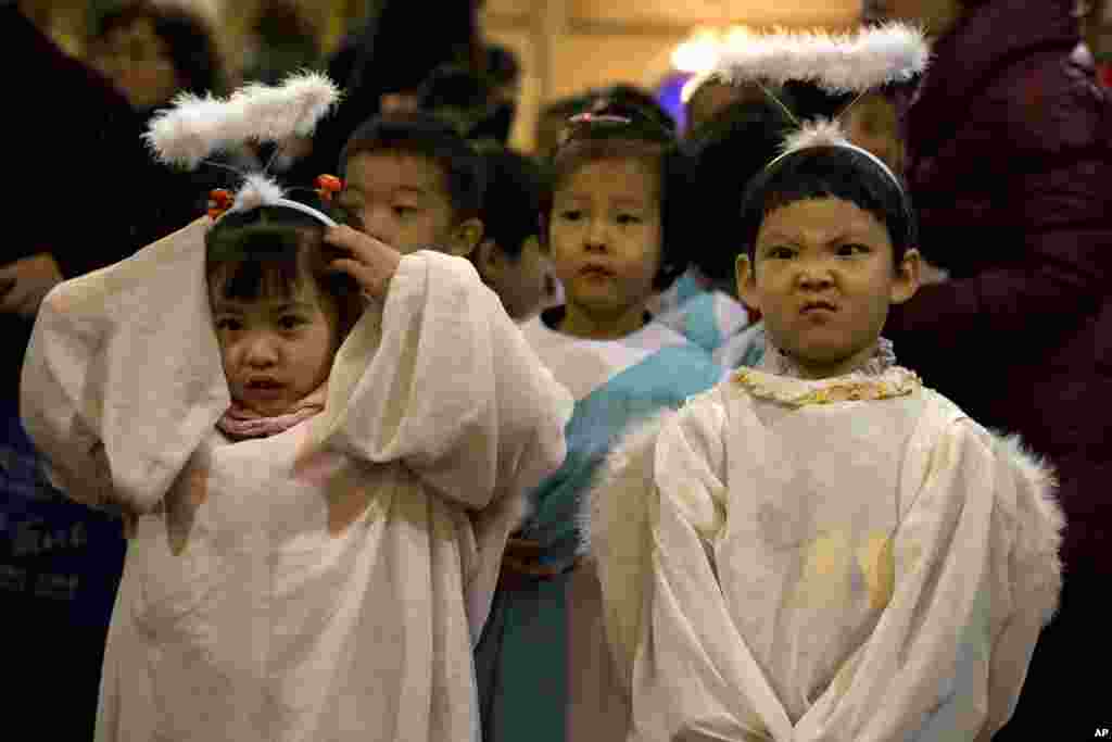 Trẻ em trong trang phục thiên thần tham gia vào một thánh lễ vào đêm trước Giáng Sinh tại một nhà thờ Công giáo ở Bắc Kinh, Trung Quốc.