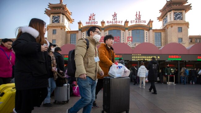 戴着口罩的旅客走在北京火车站外。(2020年1月20日)