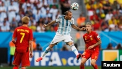 Pemain Argentina Rodrigo Palacio menyundul bola di antara pemain Belgia Kevin De Bruyne (kiri) dan Toby Alderweireld dalam pertandingan perempat final Piala Dunia 2014 di stadion nasional Brasilia di Brasilia 5 Juli 2014.