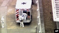 An ambulance arrives with Ebola victim Dr. Kent Brantly, right, to Emory University Hospital, Saturday, Aug. 2, 2014, in Atlanta.