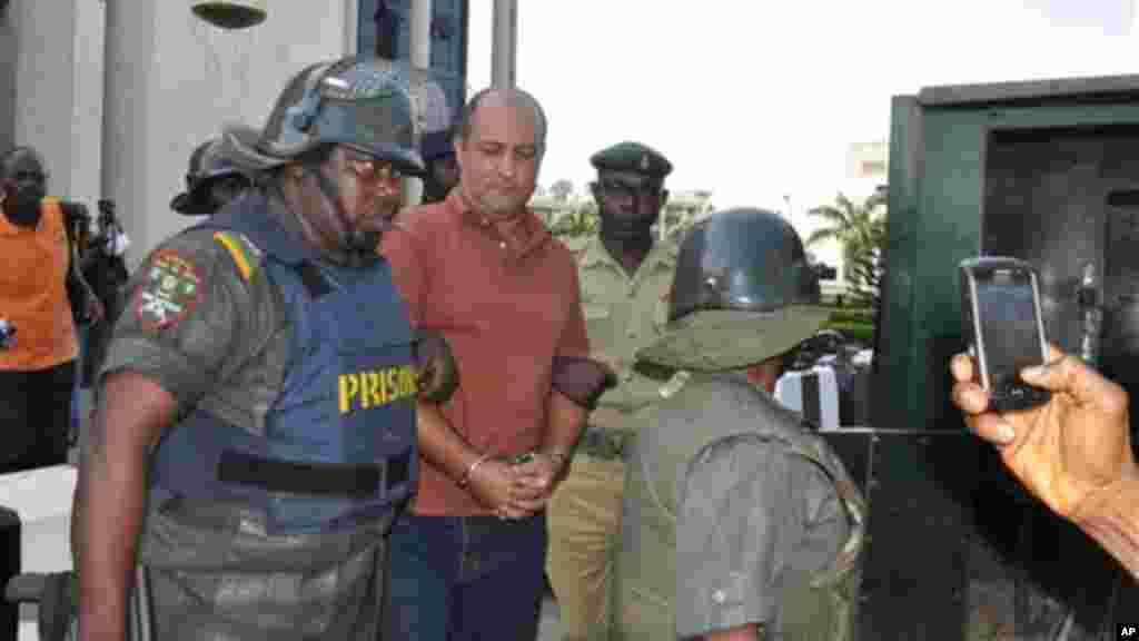 Talal Ahmad Roda, a Nigerian-Lebanese man accused of belonging to Hezbollah, centre, is led out by prison security officers after he was sentenced to life imprisonment at the Federal High Court in Abuja, Nov. 29, 2013.