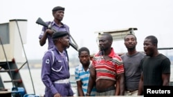 Suspected pirates are paraded aboard a naval ship after their arrest by the Nigerian Navy at a defence jetty in Lagos August 20, 2013. Commodore Chris Ezekobe, naval commander at the NNS Beecroft, a Lagos naval base, said the four had hijacked the barge a