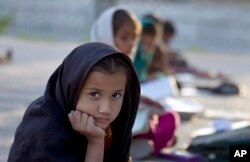 FILE - Pakistani student Farah Muneeb sits with other students at a makeshift school set up by a volunteer in a park in Islamabad, Pakistan, Oct 11, 2012.