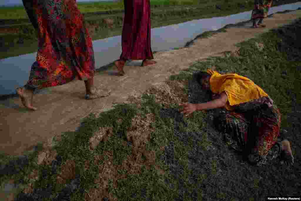 Exausta, uma refugiada Rohingya que fugia da violência no Myanmar cai e clama por ajuda na passagem para Palang Khali no Bangladesh. Nov 2, 2017