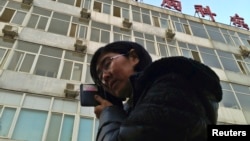 Wang Yu, the lawyer of human right activist Cao Shunli, talks on the phone in front of a hospital building where Cao is hospitalized at its intensive care unit in Beijing, March 1, 2014.