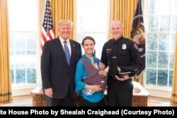 President Donald Trump welcomes State of the Union honored guests Albuquerque, N.M., police officer Ryan Holets and family to the Oval Office at the White House, in Washington, Jan. 30, 2018.