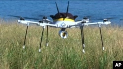 A still image taken from video shows a test drone making a UPS delivery lands on Children's Island in Marblehead, Mass., Sept. 22, 2016.