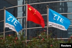 中国企业中兴通讯在深圳的总部外飘扬的该公司旗帜和中国国旗。（2016年4月28日）