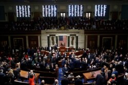 FILE - House members vote on article II of impeachment against President Donald Trump as House Speaker Nancy Pelosi of California stands on the dais on Capitol Hill in Washington, Dec. 18, 2019.