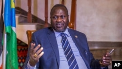 FILE - South Sudan rebel leader Riek Machar talks to reporters at his private residence in the Ethiopian capital, Addis Ababa, Feb. 13, 2016. He says he is ready to return to Juba in March to take up his position as first vice president.