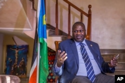 FILE - South Sudan rebel leader Riek Machar talks to reporters at his private residence in Ethiopian capital, Addis Ababa, Feb. 13, 2016. Opposition officers say the troops will not be arriving in Juba Tuesday as scheduled because the South Sudan government has not designated cantonment areas and food and medical care facilities for the troops.