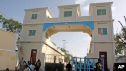 FILE - Somali soldiers stand guard at the main gate of the presidential palace in Mogadishu, July, 9, 2014.