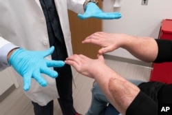 جو دی‌میو توانایی دستهایش را به دکتر ادواردو رادریگز نشان می دهد. تیم پزشکی با رهبری دکتر رادریگز دو دست دی‌میو که در اثر سوختگی آسیب دیده بود را قطع کرده و این دست‌ها را به او پیوند زدند.
