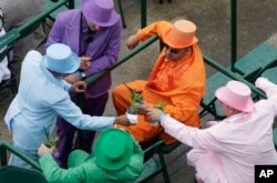 FILE - Race goers toast with mint juleps before the 136th Kentucky Derby horse race at Churchill Downs Saturday, May 1, 2010, in Louisville, Ky. (AP Photo/Charlie Riedel)