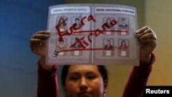 A member of the electoral committee shows a ballot that reads "Out, tyrant" during the counting of votes in the nationwide judicial elections in La Paz, Bolivia, Dec. 3, 2017. 