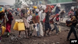 Residents carry their belongings as they flee from Kibati, where fighting has intensified, towards the city of Goma, Democratic Republic of Congo, Jan. 26, 2025. 