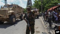 FILE - A Kenyan police officer part of a UN-backed multinational force gestures for journalists to move in Port-au-Prince, Haiti, July 17, 2024. 