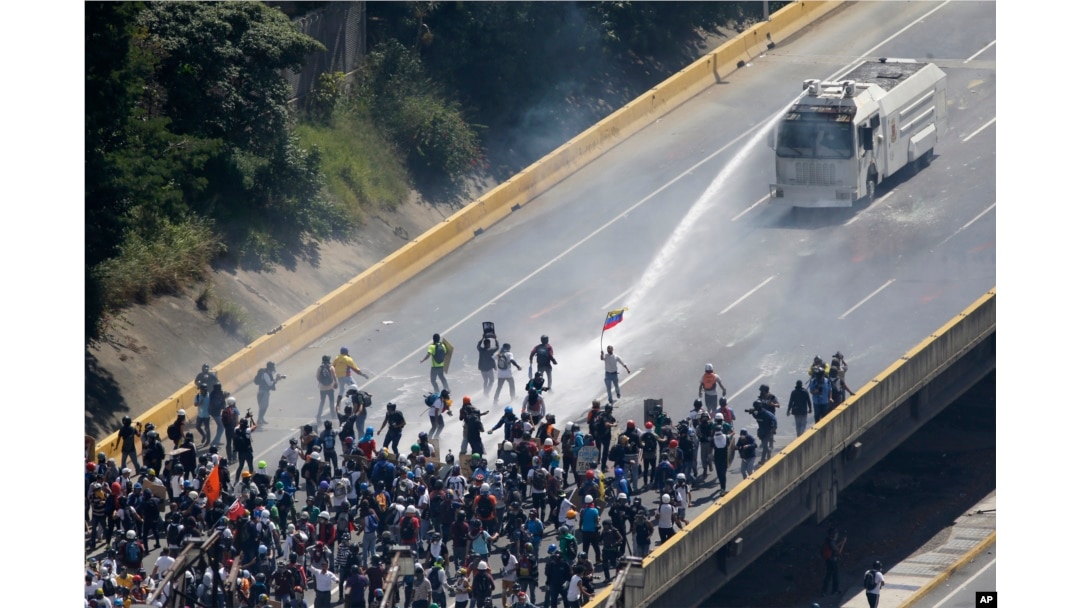 FILE - Security forces spray a water canon at opposition protesters marching to protest Venezuelan President Nicolas Maduro in Caracas, Venezuela, May 29, 2017.