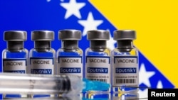 FILE - Vials labelled "Sputnik V coronavirus disease (COVID-19) vaccine" and a syringe are seen in front of a displayed Bosnian flag in this illustration picture taken March 17, 2021.
