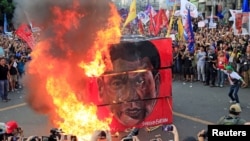 Protesters burn a cube effigy with a face of President Rodrigo Duterte during a National Day of Protest outside the presidential palace in metro Manila, Philippines Sept. 21, 2017. 