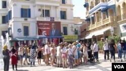 Tourists at the medina in Tunis are flanked by campaign posters, Sept. 13, 2019. (L. Bryant/VOA) 