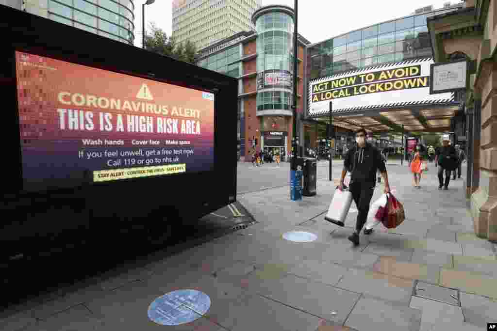 Public information messages in central Manchester England, are posted after British Prime Minister Boris Johnson set out new restrictions to last &quot;perhaps six months&quot; to slow the renewed spread of coronavirus.