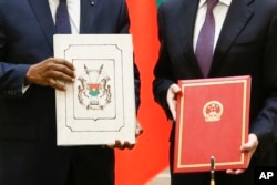 China's Foreign Minister Wang Yi, right, and Burkina Faso Foreign Minister Alpha Barry display documents establishing diplomatic relations between the two countries in Beijing, May 26, 2018.