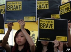 Supporters raise placards outside a court in Hong Kong, April 9, 2019.