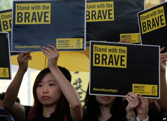Supporters raise placards outside a court in Hong Kong, April 9, 2019.