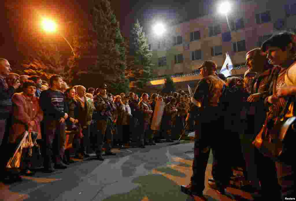 Pro-Russian activists wait outside the regional police headquarters in Luhansk, eastern Ukraine, April 29, 2014.