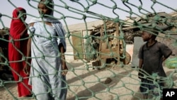 FILE - People stand outside their home in a poor neighborhood of Nouakchott, Mauritania, where a landmark law was passed on Aug. 8, 2007 to jail anyone who keeps slaves.