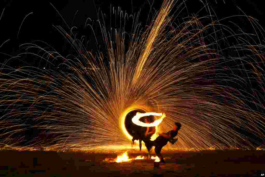 Malay artists perform a fire sparkling performance on a beach side during the Christmas festive season and school holidays on Pangkor Island, Malaysia.&nbsp;(AP Photo/Andy Wong)