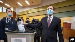 Albin Kurti, right, a candidate for prime minister of Vetevendosje (Self-Determination), casts his ballot paper in parliamentary elections in capital Pristina, Kosovo, Sunday, Feb. 14, 2021. Kosovo is holding an early parliamentary election to form…